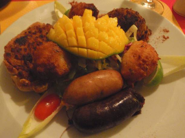 Gourmet plate.  Creole cuisine.  Stuffed christophine, cod Accra, spicy black pudding, stuffed crab. Exotic Caribbean meal.  Creole and spicy cuisine.  Stuffed christophine, Accras, black pudding.  Delight for the taste buds Christophine stock pictures, royalty-free photos & images