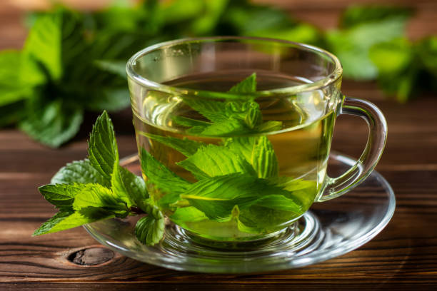 istock Cup of mint tea and a bunch of mint on the table 1400256847
