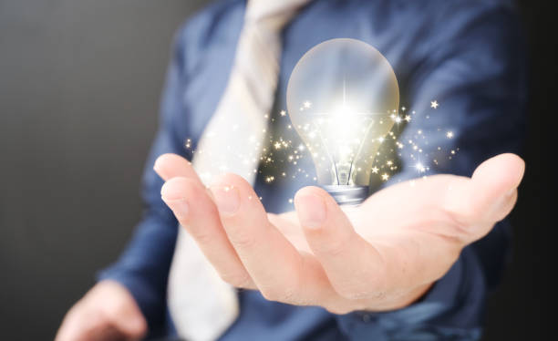 istock Hands holding a light bulb to represent an idea notion with innovation and inspiration, inventive scientific technology, and innovative idea Perspective and networking On a global network connection 1400256921
