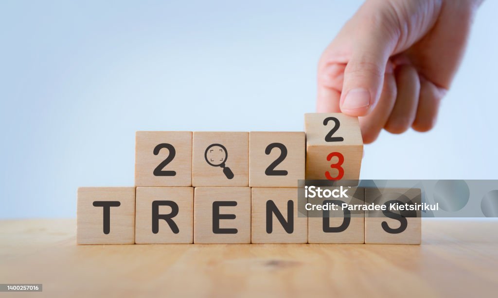 2023 trend concept. Hand flip wooden cube change year 2022 to 2023. Beautiful white background, copy space. Used for the banner trend concept of the new year for monitoring new business opportunities. 2023 Stock Photo