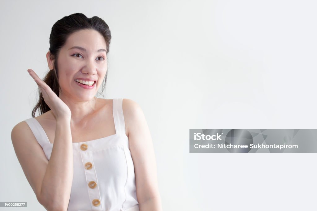 Asian beautiful woman  raise a hand beside her face are smiling with happiness. Good healthy and Mental Asian beautiful woman  raise a hand beside her face are smiling with happiness. A Good healthy and Mental Adult Stock Photo