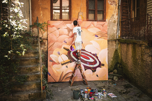 Male artist working on a big painting. Creative occupation concept.