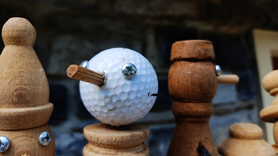 funny little wooden man with head made with a golf ball