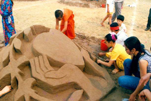 In 1995,Water Splashing Festival in Xishuangbanna,Sand sculpture contest,boy monk also participate The festival lasts for several days, with dragon-boat races, water splashing, traditional songs and dances, fairs and cockfighting,crossbows, sand sculptures and more friendly competitions.Film photo in April 1995,Xishuangbanna,Southern Yunnan xishuangbanna stock pictures, royalty-free photos & images