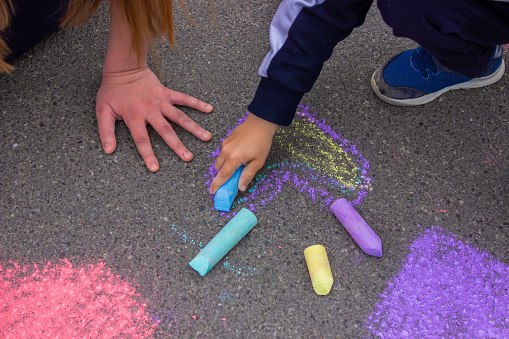 child's hand draws hearts, draws with chalk on the pavement. selective focus
