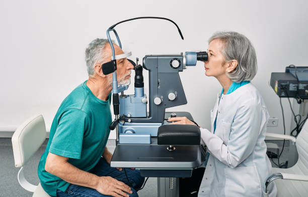 exame ocular e diagnóstico de visão. optometrista feminino fazendo teste de visão para idoso em clínica de oftalmologia moderna - patient senior adult optometrist eye exam - fotografias e filmes do acervo