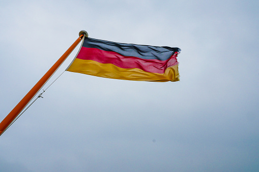 German flag on blue sky. Low angle view.
