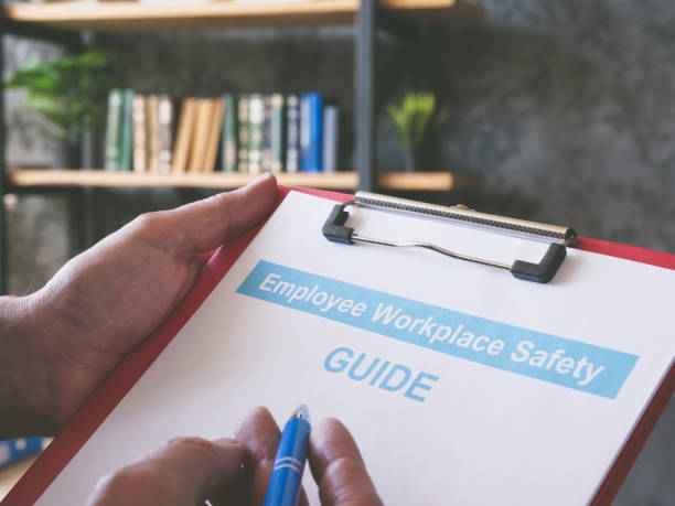 istock Man reads employee workplace safety guide in the office. 1400265145
