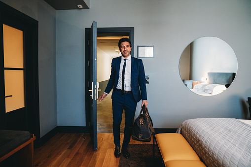 A businessman is entering in an hotel room. View from inside the room.