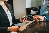 A businessman is paying with credit card at the hotel reception