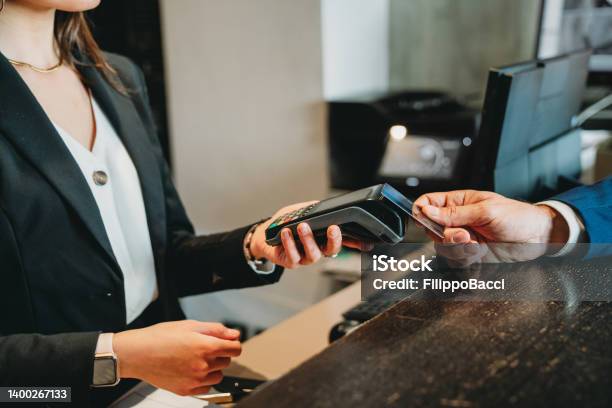 A Businessman Is Paying With Credit Card At The Hotel Reception Stock Photo - Download Image Now