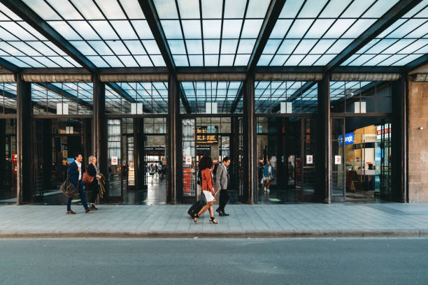 People are walking outside a railroad station. Business people in a business trip together.