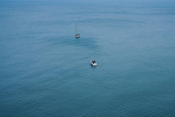 High-angle shot captures a speedboat slicing through serene blue waters, leaving a trail behind. The scene conveys motion and tranquility, ideal for dynamic yet peaceful compositions.