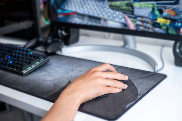istock selective focus of a teenager hand playing on a gaming computer, with a black keyboard on a large gray mouse pad, online network games, addition to video games 1400270295