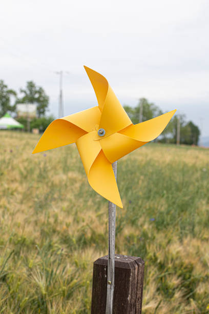 istock Rotating toy windmill in green grass field. 1400271424