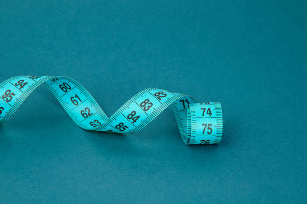 istock Colorful tape measure spiral with copyspace blue background 1400271859