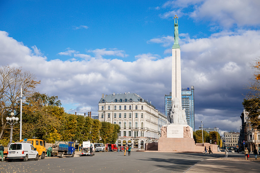 Riga, Latvia, 14 October 2021: Freedom Monument honoring soldiers killed during Latvian War of Independence, statue of granite, travertine and copper on Freedom Boulevard at sunny day