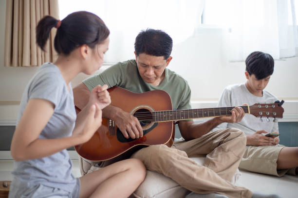 istock daughter teaching father to play guitar 1400277115