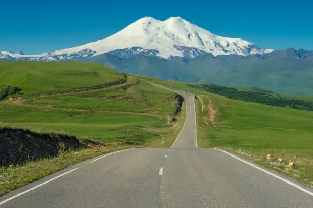 Road leading to mount Elbrus with green meadows at summer. North Caucasus, Russia