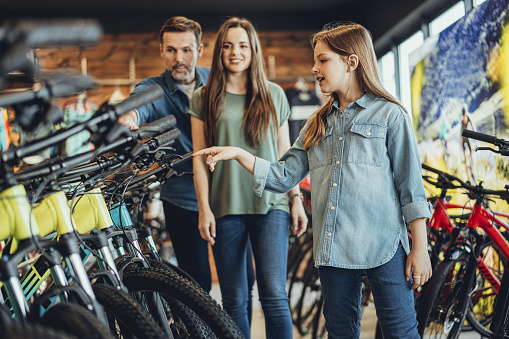 Family testing bicycles in bike shop