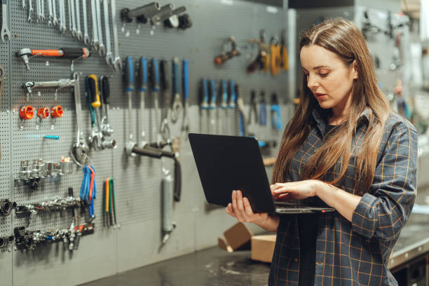 istock bicycle store - Female Bicycle Mechanic with laptop 1400277321