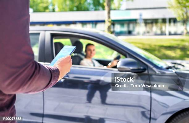 Taxi Phone App For Cab Or Car Ride Share Service Customer Waiting Driver To Pick Up On City Street Man Holding Smartphone Stock Photo - Download Image Now