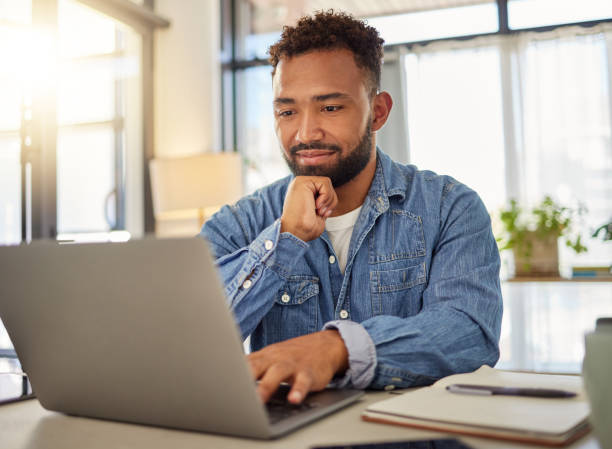 glücklicher geschäftsmann, der zu hause an seinem laptop arbeitet. gut aussehender geschäftsmann, der zu hause eine e-mail auf seinem laptop liest. freiberuflicher unternehmer, der zu hause auf seinem laptop tippt. virtueller remote-mitarbeiter zu hause - computer people stock-fotos und bilder