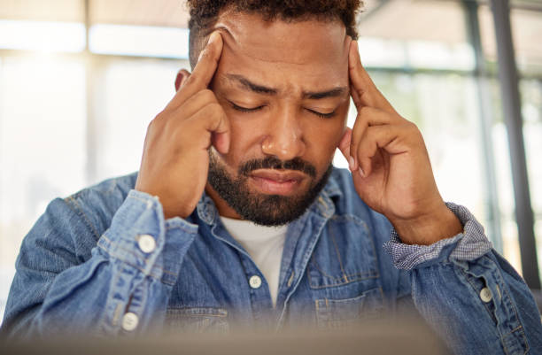 istock Young man looking stressed with a headache at home. Man feeling anxious with a migraine at home. Depressed young man with a headache at home. bachelor having a breakdown crisis at home 1400280376