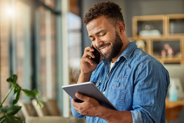 istock Businessman reading an email on his digital tablet. Young freelance entrepreneur making s call on his cellphone at home. Hispanic businessman working on his wireless device at home 1400280377