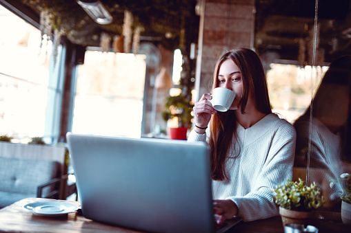 Cute Female Freelancer Starting Work Early With Coffee And Laptop
