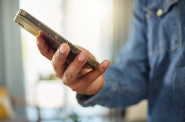 istock Hands of a man using his cellphone to send a text message. Bachelor connected to the internet with his smartphone. Always online using apps on his mobile phone. Hands of a man using a cellphone 1400281671