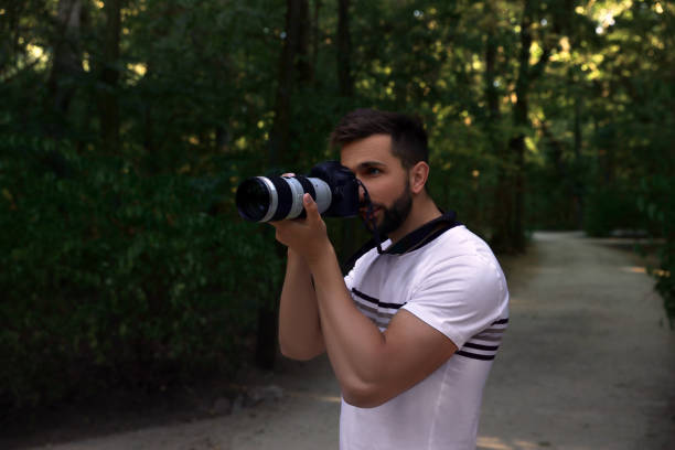 istock Handsome man with camera spending time in nature reserve 1400284676