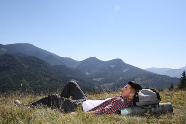 istock Tourist with backpack resting on ground in mountains 1400285142