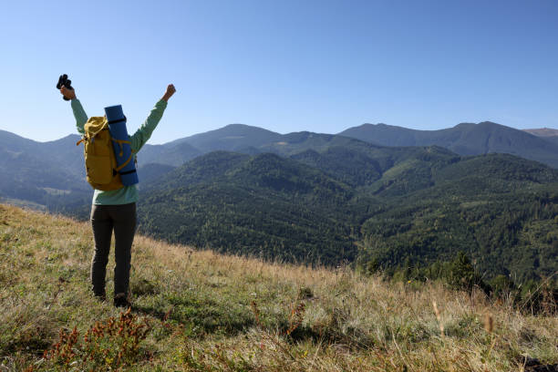istock Happy tourist with backpack and binoculars in mountains on sunny day, back view 1400285194
