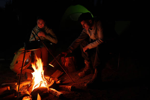 istock Couple sitting near bonfire in camp at night 1400286328