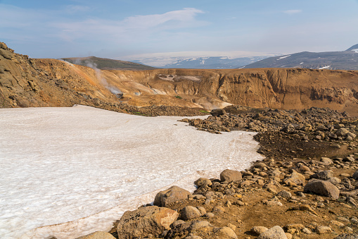 Beautiful landscape of Hveradalir  geothermal area against blue sky on sunny day, some snow and some barren orange rocks, Iceland