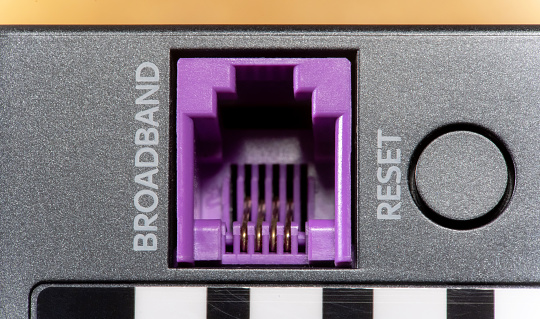 Broadband internet connection cable input socket, port on a network device modern router or WiFi access point, object detail, extreme closeup, zoom in. Networking, wide bandwidth data transmission