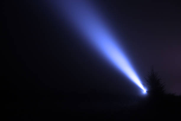 istock Night sky lit by bright beam of flashlight in forest 1400288895
