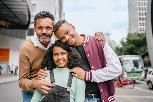 Gay couple with adopted girl at Paulista Avenue in Sao Paulo , Brazil stock photo