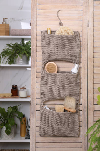 istock Storage with essentials hanging on wooden folding screen in bathroom. Stylish accessory 1400290919