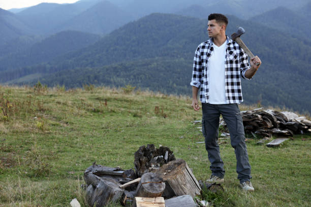 istock Handsome man with axe and cut firewood in mountains 1400291046