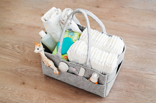 Mothers bag with toy and accessories on white background