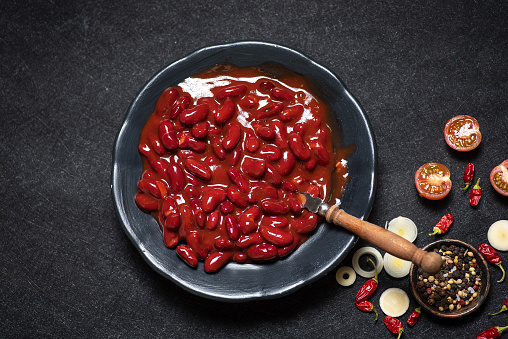 Red Mexican beans in a ceramic bowl on a rustic black-gray background