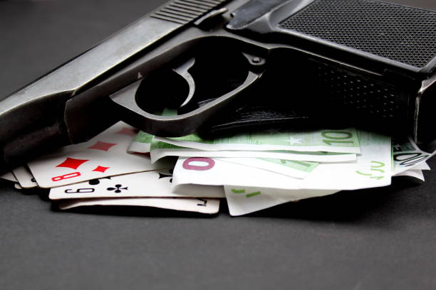 tarjetas de dinero y pistola sobre fondo negro - dice currency gambling risk fotografías e imágenes de stock