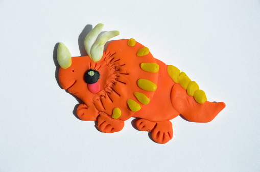 cute children's craft. a colored dinosaur made by the hands of a child