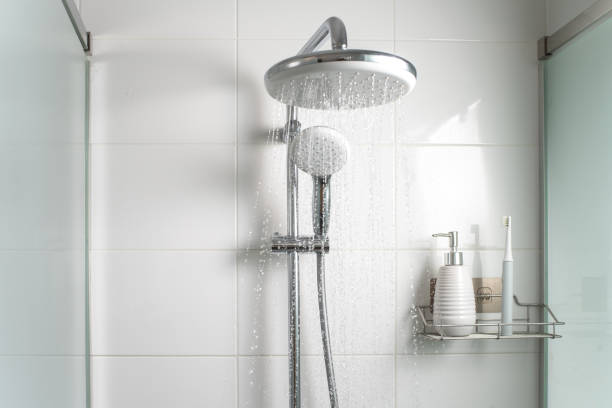 düsen von sauberem wasser, die in der duschkabine fließen. - duschkopf stock-fotos und bilder