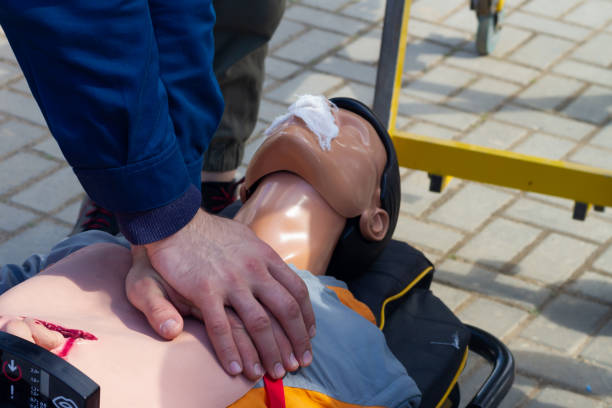Resuscitation of a training plastic doll on a medical gurney, indirect heart massage tutorial stock photo