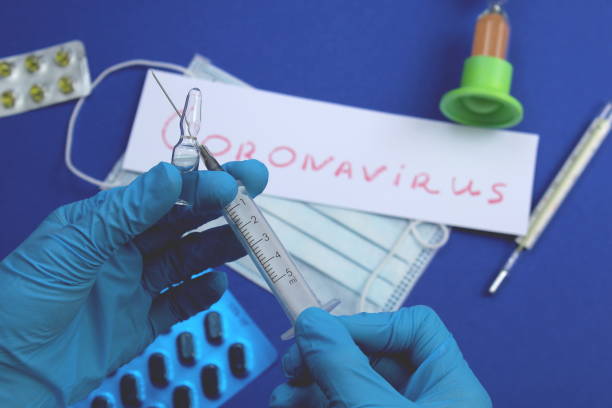 istock Hands in blue gloves hold a syringe and ampoule 1400298070