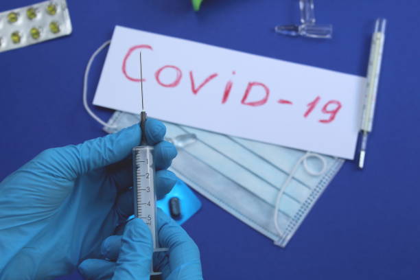 istock Hands in blue gloves hold a syringe and ampoule 1400298243
