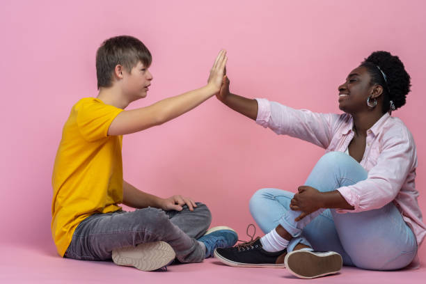 istock Guy and woman touching palms sitting on floor 1400298294